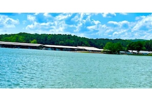 A lakeside view with a building featuring a long, flat roof and a covered area.