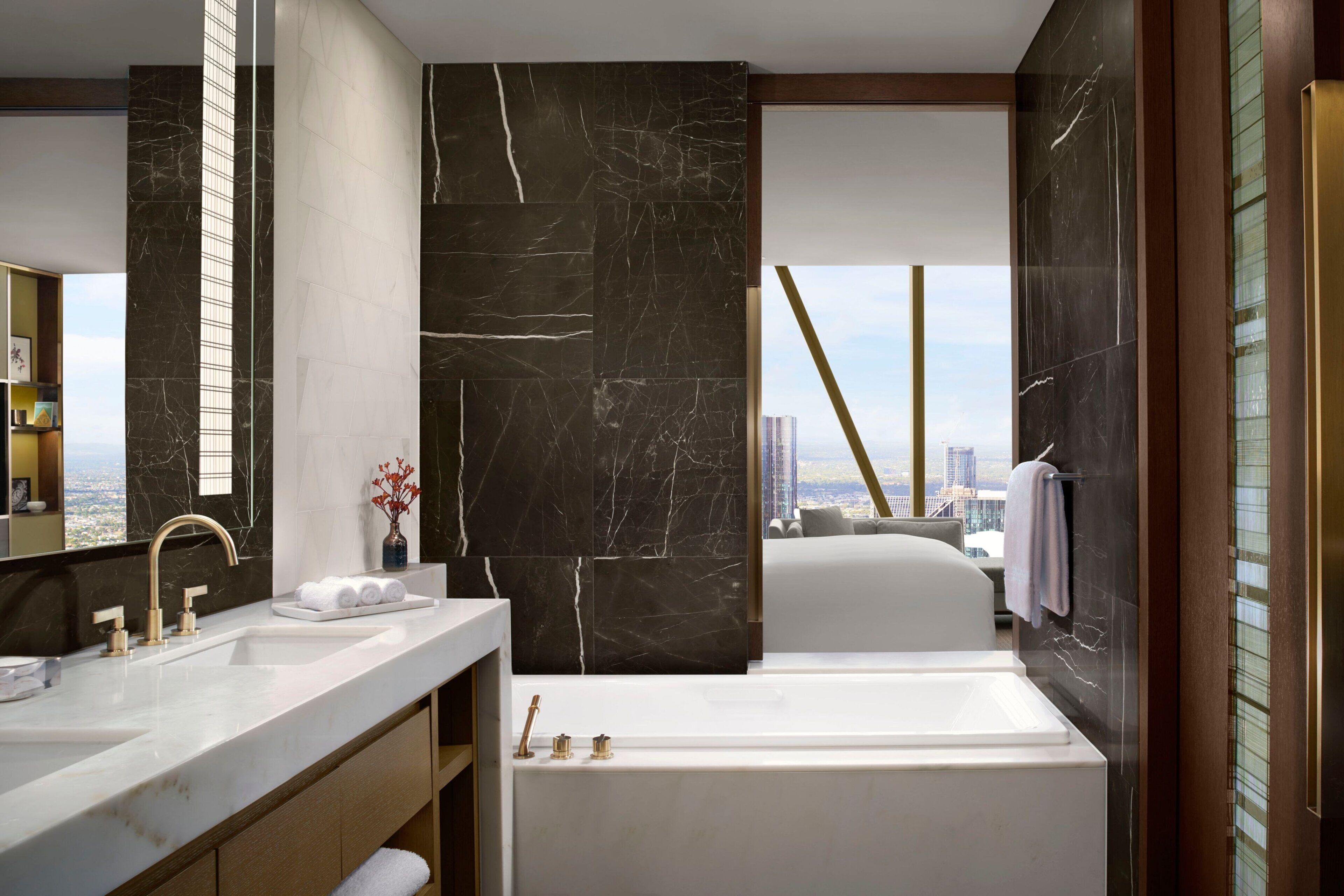Un baño moderno con una bañera grande, un lavamanos doble y un espejo amplio.