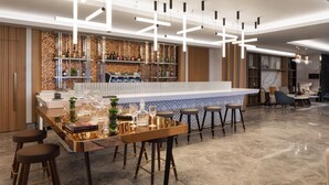 A modern bar area with a long counter, stools, and a decorative wall. - Tirana Marriott (Tirana)