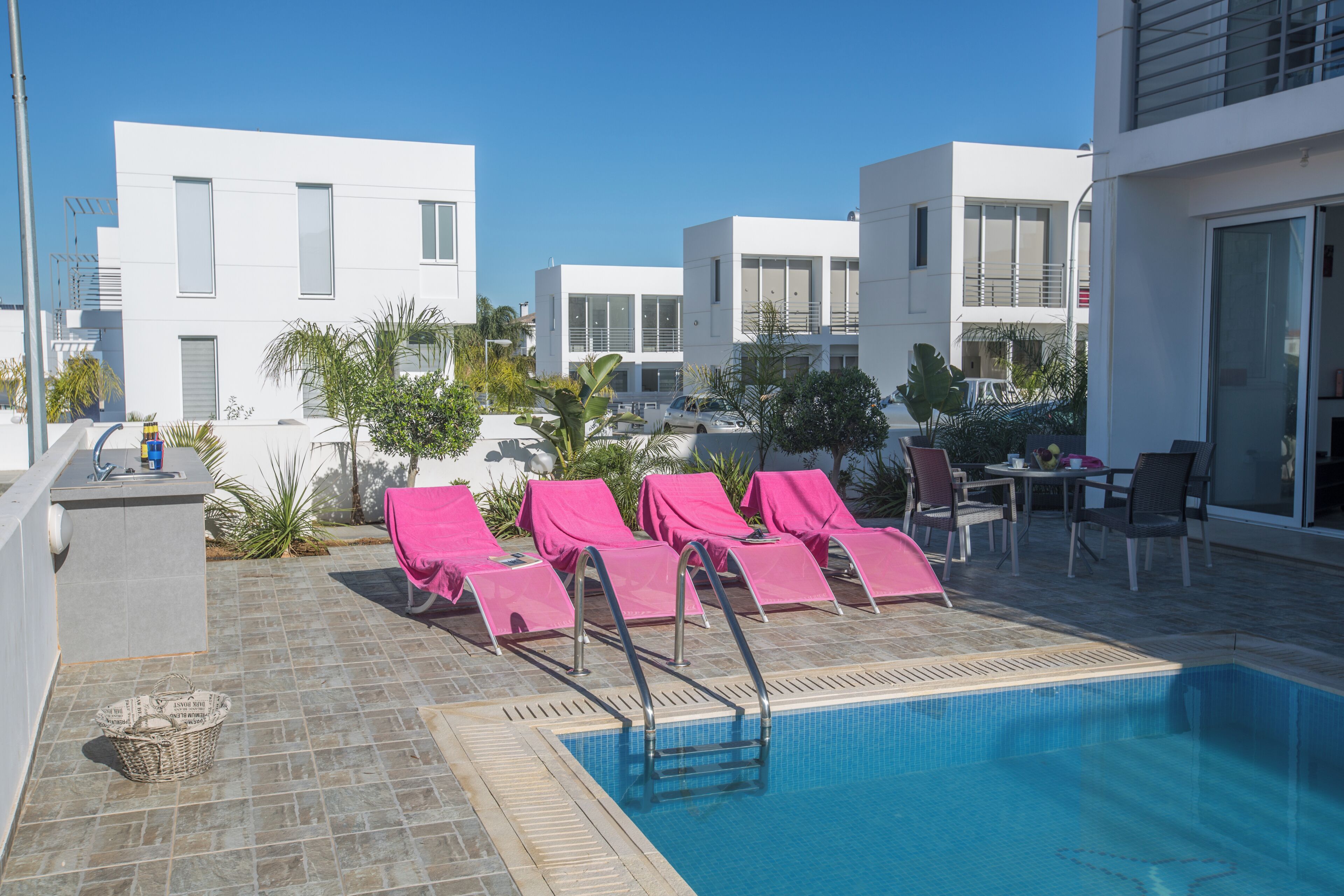 A modern pool area with lounge chairs and a clear blue pool.
