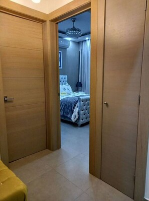 A bedroom with a bed, a nightstand, a lamp, and a ceiling fan. - Luxury Condo 1 Br Pool Excellent Location (Santo Domingo)