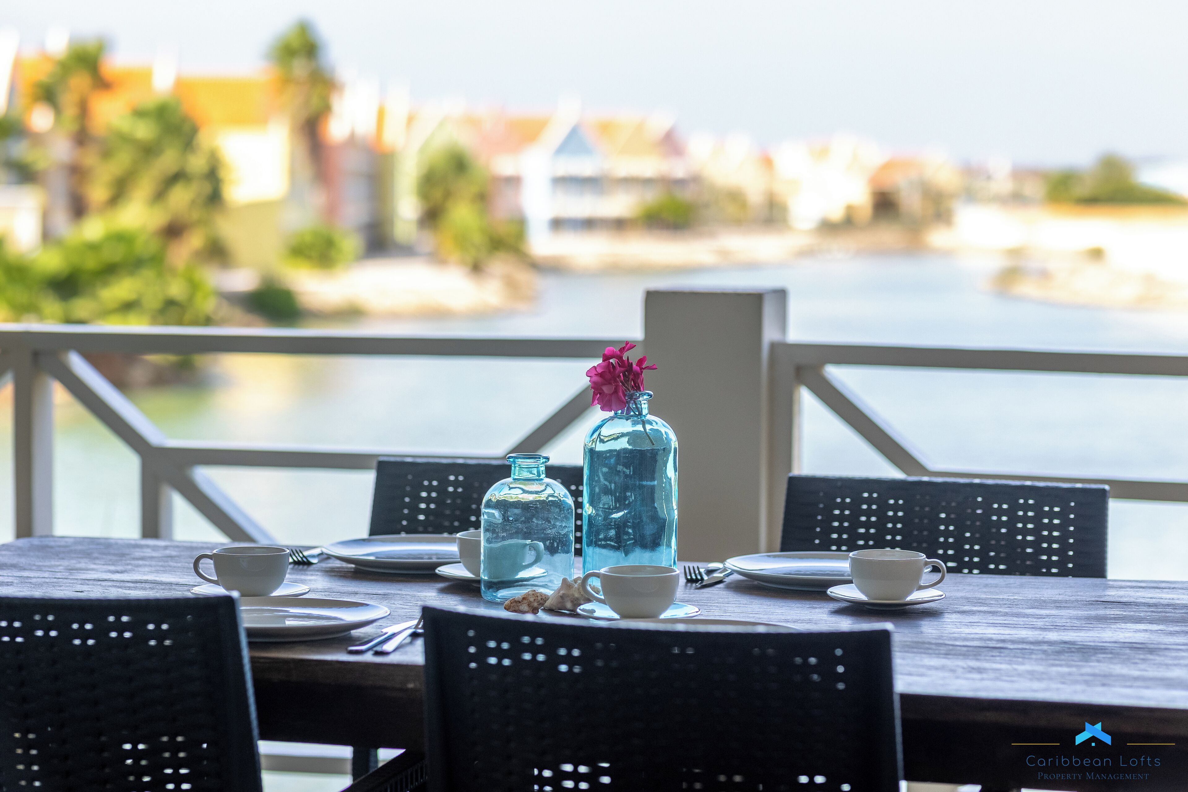 Una mesa de comedor con vistas a un cuerpo de agua y edificios al fondo.