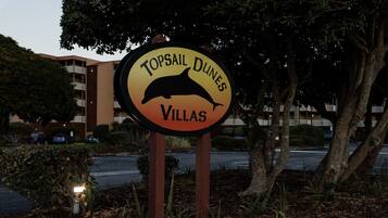 A sign for Topsail Dunes Villas with a dolphin graphic.