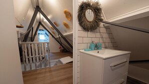 Ein Badezimmer mit weißem Waschtisch, einem Spiegel und einem hängenden Handtuchhalter.