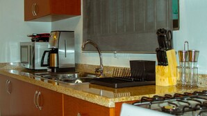 A kitchen with a stainless steel sink, a coffee maker, a knife block, and a gas stove. - 5 minutes from eagle beach as an apartment with kitchen and (Noord)