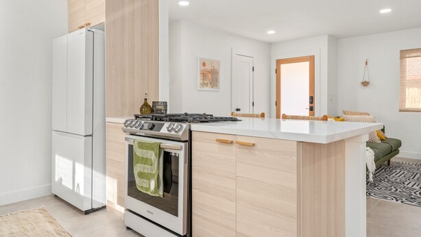 A modern kitchen with a built-in oven, a stove, and a refrigerator.