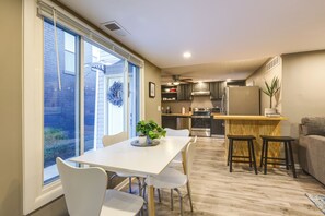 Una cocina moderna con comedor, ventanas amplias y un ventilador de techo.