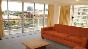 Enjoy a city view from the large window in this stylish room, featuring a comfortable sofa and side table.