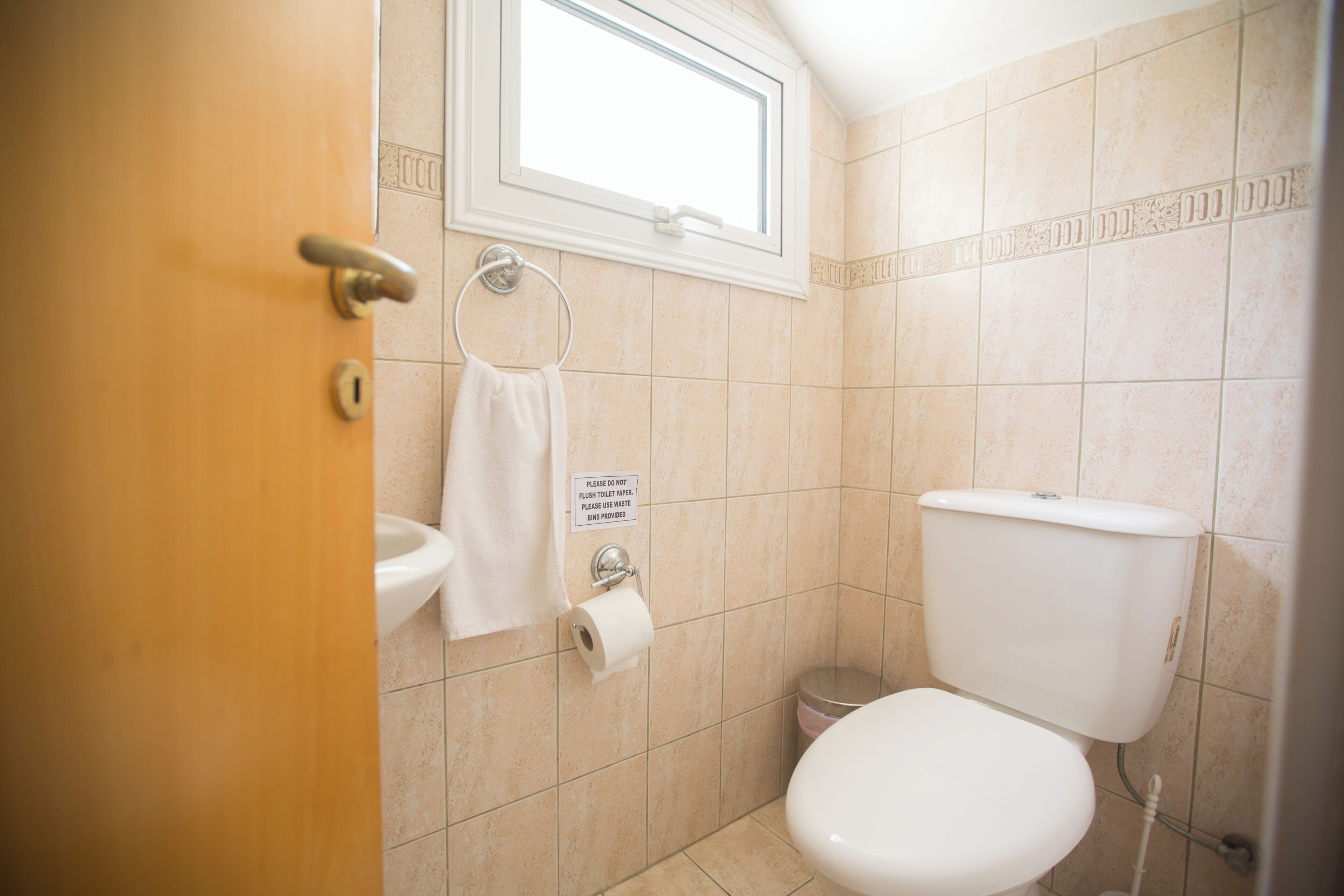 Une salle de bain avec des toilettes, un lavabo et un porte-serviettes.