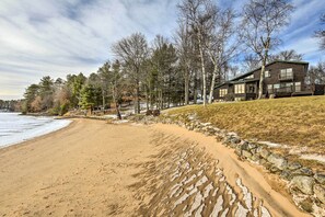 Situated on a sandy beach, this cabin offers a balcony with a view of the surrounding forest and grassy area.