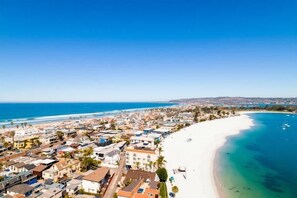 An aerial view of a coastal town with a beach, buildings, and clear blue sky. - Large Waterfront | Private Roof Deck | Fireworks View (San Diego)