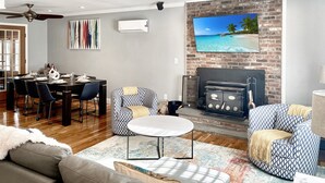 Ein modernes Wohnzimmer mit Kamin, Essbereich und gemütlicher Sitzecke.