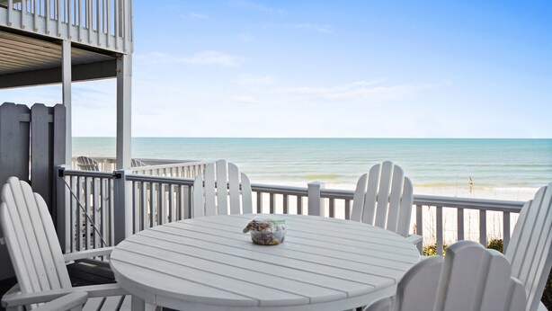 A white deck with a round table and chairs, overlooking a beach. - Gulf Front-Unobstructed Views! Book Now! (Port St. Joe)