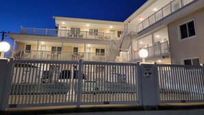 A multi-story hotel with balconies and a gated entrance.
