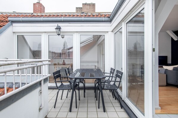 Relax in a cozy outdoor space with a table and six chairs, perfect for al fresco dining.