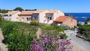A coastal residential area with terraced houses, a clear blue sky, and a view of the sea. - Cosy apartment for 4 people with WIFI, A/C, TV, terrace and pets allowed (Fréjus)