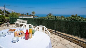 An outdoor dining area with a table set for breakfast, overlooking a coastal view. - Cosy apartment for 4 people with WIFI, A/C, TV, terrace and pets allowed (Fréjus)