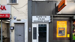 Liiketila Edgware Roadilla, jossa on kyltti, jossa lukee, että siellä on huoneistot 1–10. Lisäksi siinä on ovi, jonka numeron alla on 326, ja Sainsbury’s-pankin mainos.