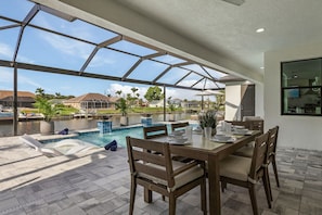 Outdoor dining - TRUE LUXURY! Brand New Home with Heated Pool, Kayaks. - Villa Luxuria Blanca - Roelens Vacations (Cape Coral)