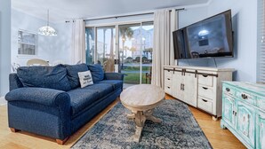 A living room with a sofa, a coffee table, a TV, and a cabinet.