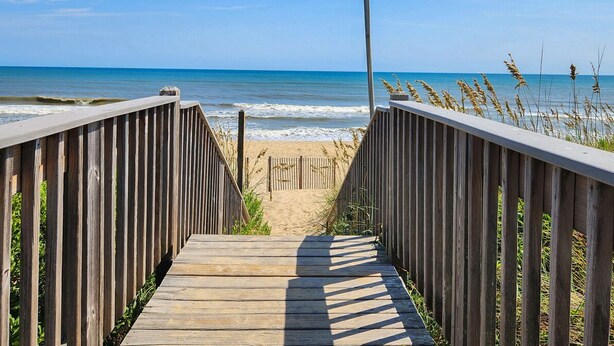A wooden boardwalk leading to a beach with a clear view of the ocean. - Blue Skies - Bright, Spaciuos 4 BR oceanside home w/Private Pool and Hot Tub (Southern Shores)