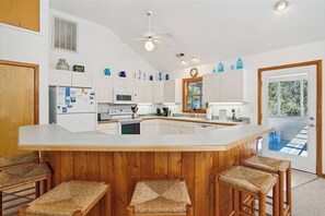 Enjoy cooking in this well-lit kitchen with a large island and bar stools.