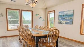 A dining room with a large wooden table, matching chairs, and a chandelier. - Vitamin Sea - Recently updated 4 BR oceanside home w/Private Pool and Hot Tub (Duck)