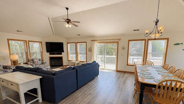 A spacious living area with a sofa set, dining table, and chairs, large windows, and a ceiling fan. - Vitamin Sea - Recently updated 4 BR oceanside home w/Private Pool and Hot Tub (Duck)