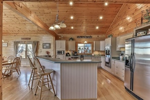 A cabin-style kitchen with a central island, wooden ceiling, and built-in appliances. - Carter`s Lake Overlook | Ellijay, Ga (Ellijay)