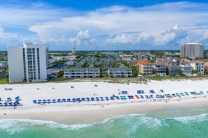 A coastal hotel area with beachfront properties, a water tower, and a large building.