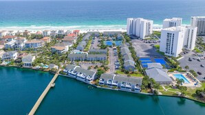 Un hotel costero con varias edificaciones, un puerto deportivo y vista a la playa.