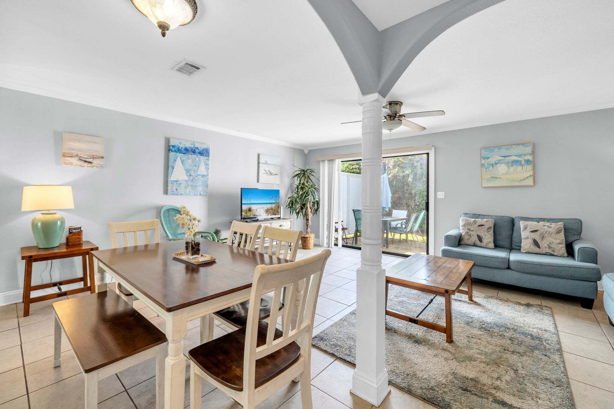 A dining area with a wooden table and chairs, a sofa, and a TV.
