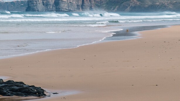 A beach with waves, a rocky cliff, and a clear sky. - Beautiful 2-Bed House in Lagoa Torrinha, Algarve (Lagoa Torrinha)
