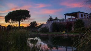 A historic building with a covered patio and a pond in the foreground. - Beautiful 2-Bed House in Lagoa Torrinha, Algarve (Lagoa Torrinha)