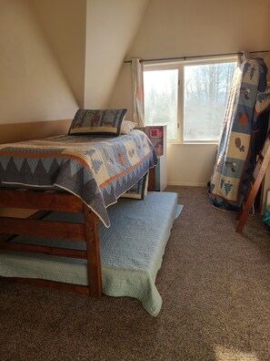 Une chambre à coucher avec un lit, une fenêtre et une chaise.