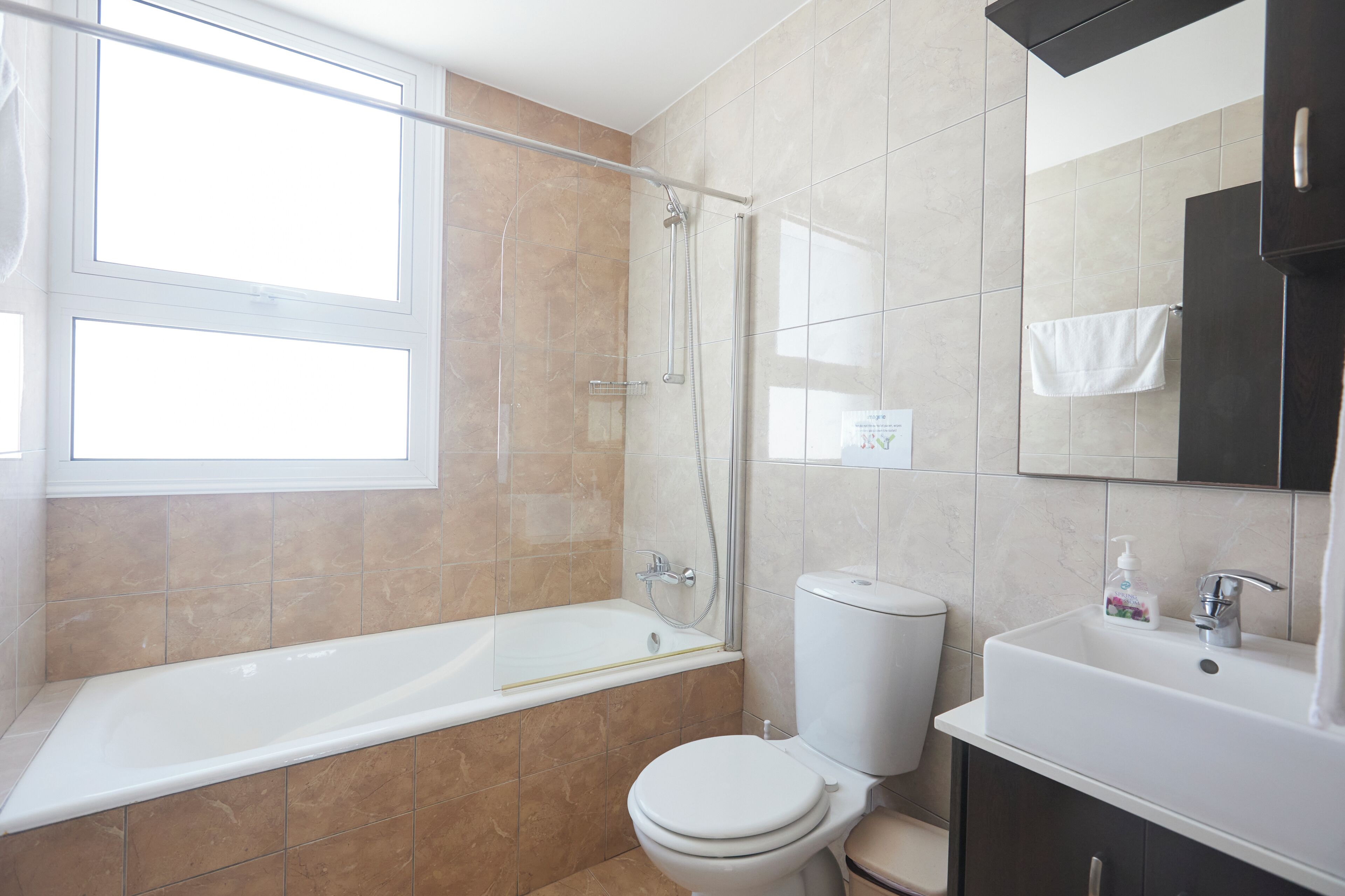 Ein modernes Badezimmer mit Badewanne, Toilette und Waschbecken.