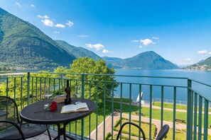 A balcony with a table, chairs, a book, and a bottle.