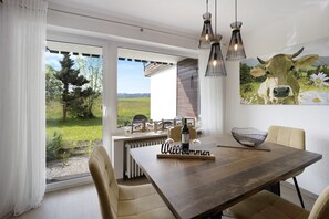 A dining area with a table, chairs, a bottle, and a bowl.