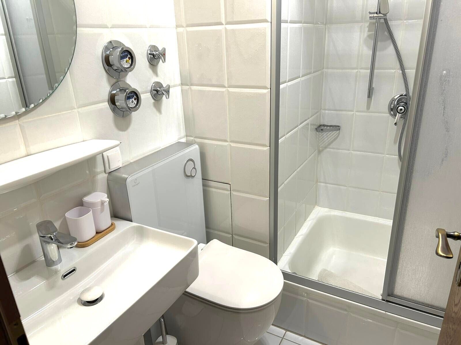 Une salle de bain avec des toilettes, un lavabo et une douche.
