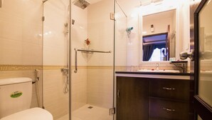 Une salle de bain moderne avec une douche à parois de verre, des toilettes et un meuble-lavabo avec un miroir.