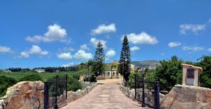 A pathway leading to a building with a stone wall on one side and a gate on the other. - Fabulous Villa In Coral Bay Near Beach, Amenities (Peyia)