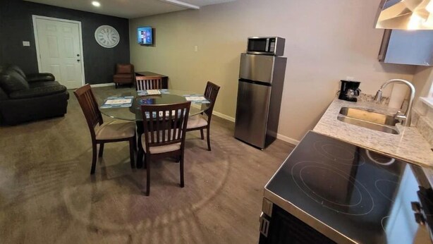 Un espace de vie compact comprenant un coin repas, une kitchenette et un salon.
