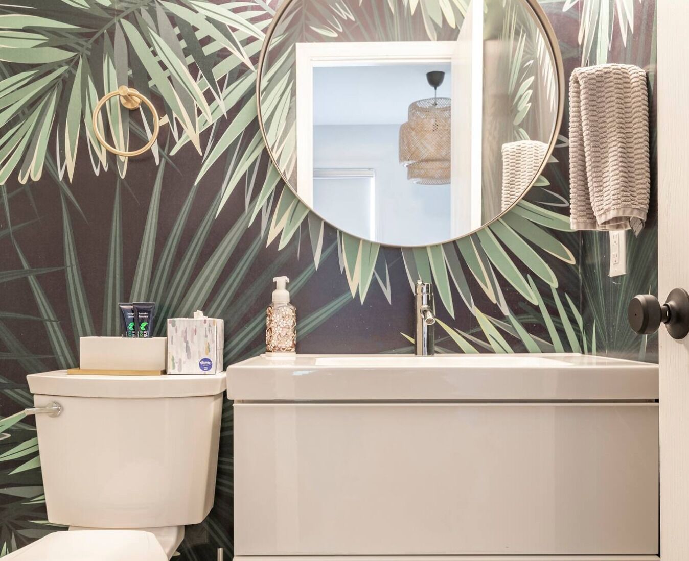 A bathroom with a toilet, sink, and mirror.