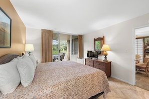 Een hotelkamer met een bed, een televisie, een bureau en een stoel.