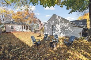 Relax in the comfort of this cozy home, where a fire pit and Adirondack chairs invite social gatherings.