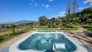 A hot tub with a clear view of the surrounding landscape, including trees and distant mountains. - Apt 5 Aircon, Wifi, Infinity Pool, Jacuzzi, Gardens Incredible! Sleeps 4 (Spoleto)