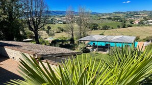 A villa with a stone terrace, a swimming pool, and a view of the countryside. - Apt 5 Aircon, Wifi, Infinity Pool, Jacuzzi, Gardens Incredible! Sleeps 4 (Spoleto)