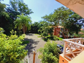 Stroll through the beautifully maintained garden along the paved pathway, surrounded by lush shrubs and trees.