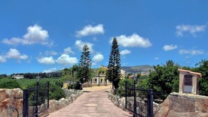 A pathway leading to a building with a stone wall on one side and a gate on the other.
