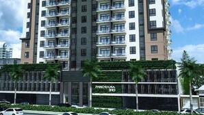A multi-story residential building with balconies, a clear sky, and palm trees. - Goistay Discover Unparalleled Elegance in the Clouds A Luxury Apartment in th (Santo Domingo)